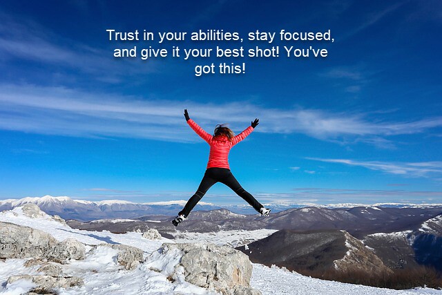person jumping on top of a mountain with white overlay text that says Trust in your abilities, stay focused, and give it your best shot You've got this!